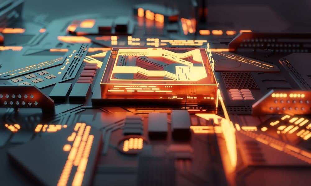 Close-up of a computer motherboard with an illuminated central chip and orange glow, circuitry visible around it.